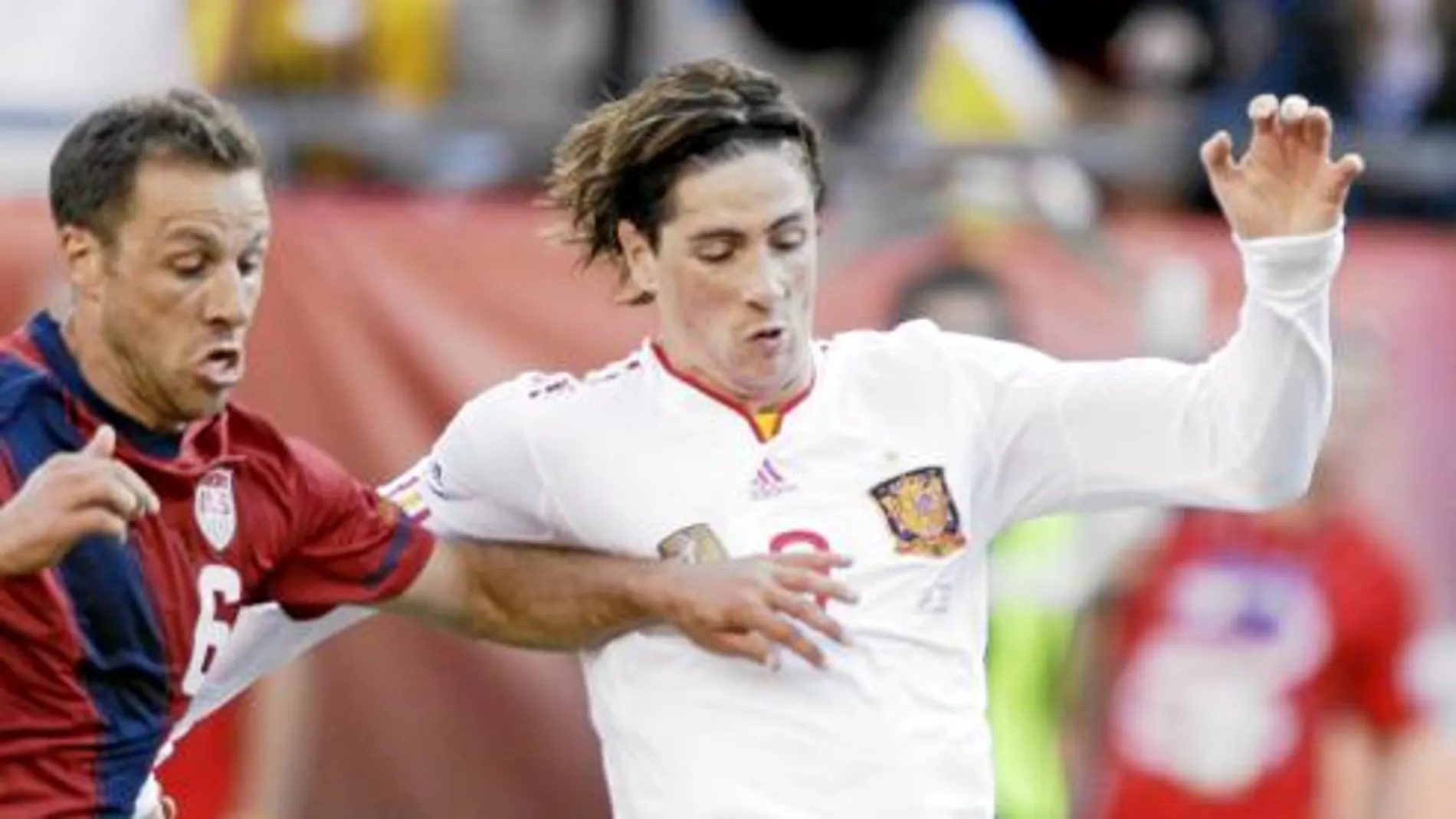 Fernando Torres intenta avanzar con el balón controlado ante la presión del futbolista de Estados Unidos Cherundolo