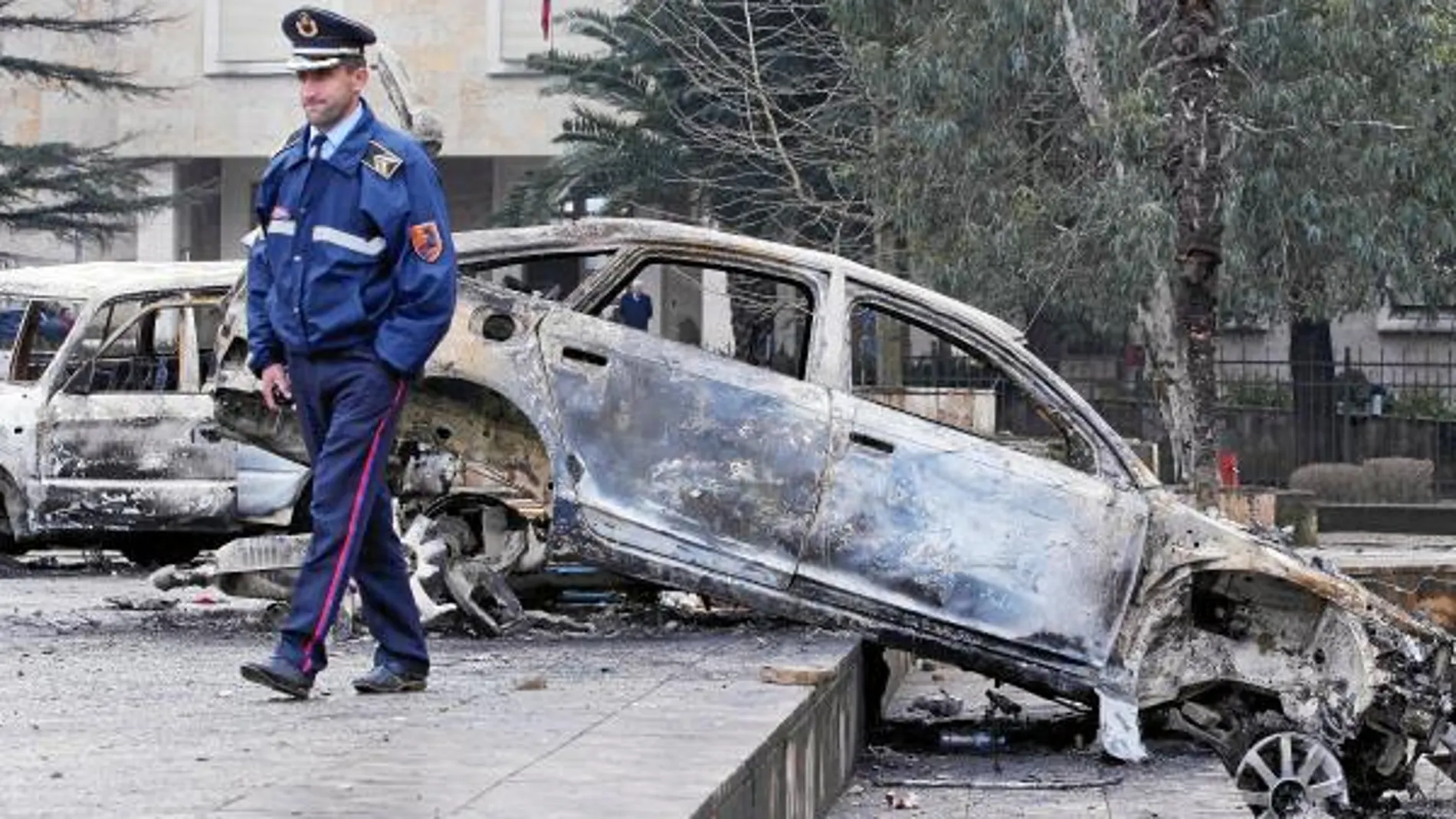 Un agente de la Policía pasa por la zona de Tirana donde el viernes se produjeron violentas protestas contra el Gobierno