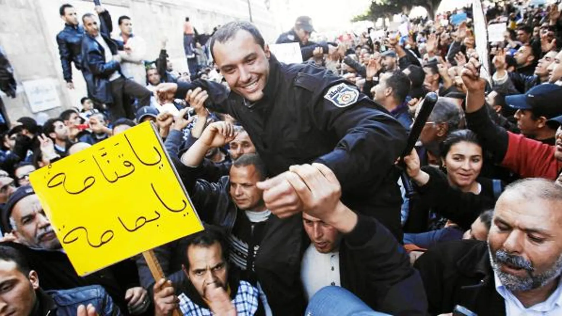 Varios manifestantes llevan a hombros a un policía durante las protestas de ayer en Túnez