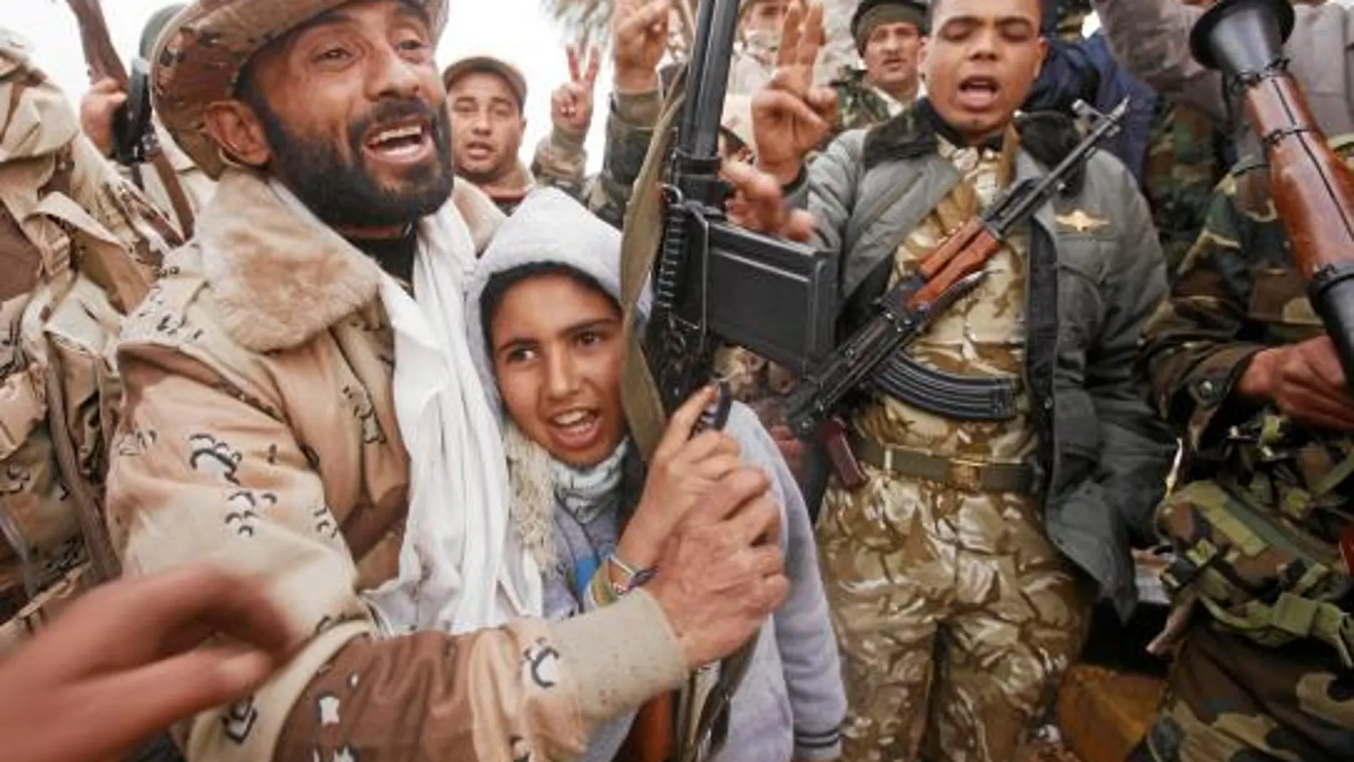 Rebeldes y ex soldados de Gadafi celebran juntos la toma de un acuartelamiento en Bengasi
