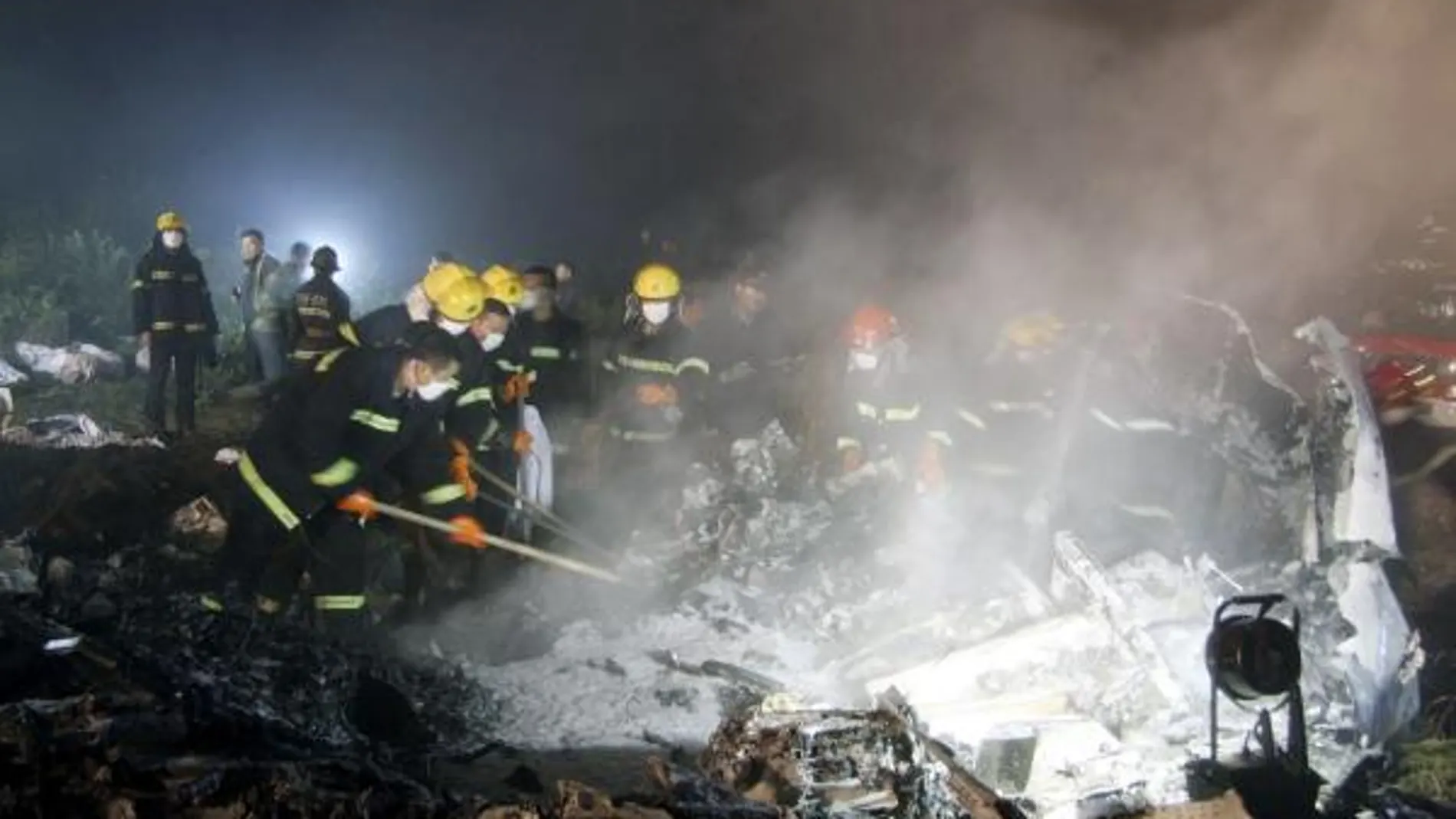 Los equipos de rescate buscan a las víctimas entre los restos del avión estrellado en Yichum (noreste de China)