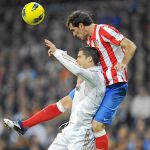 Godín salta por encima de Cristiano Ronaldo y despeja la pelota de cabeza en el derbi jugado ayer en el Bernabéu