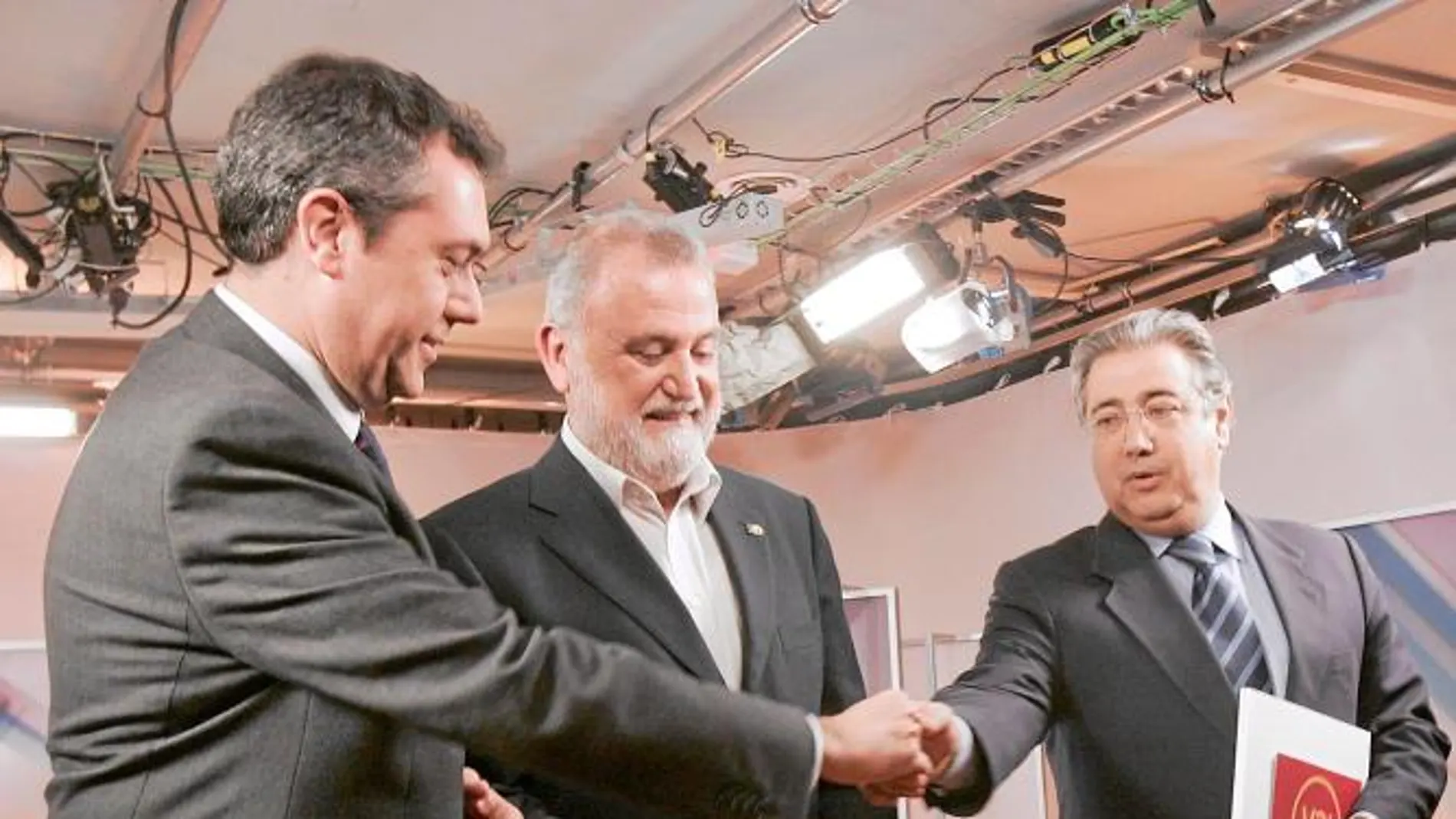 Juan Espadas y Juan Ignacio Zoido se estrechan la mano ante un indeciso Torrijos antes de un debate