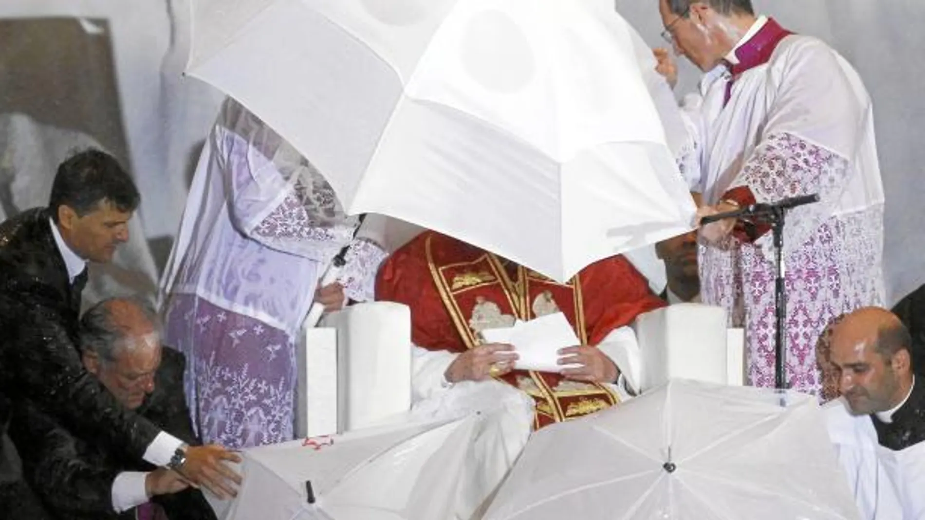 Los acólitos protegen al Santo Padre durante la vigilia de oración cuando el temporal arreció en el aeródromo