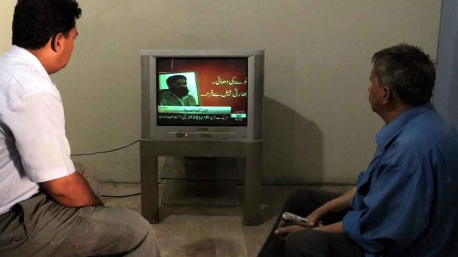 Un hombre paquistaní sigue por televisión la noticia de la muerte del alto mando de la red terrorista Al Qaeda en Pakistán Ilyas Kashmiri
