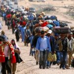 Miles de trabajadores bengalíes caminan, con sus pertenencias, hasta la frontera de Túnez huyendo de los combates en Libia