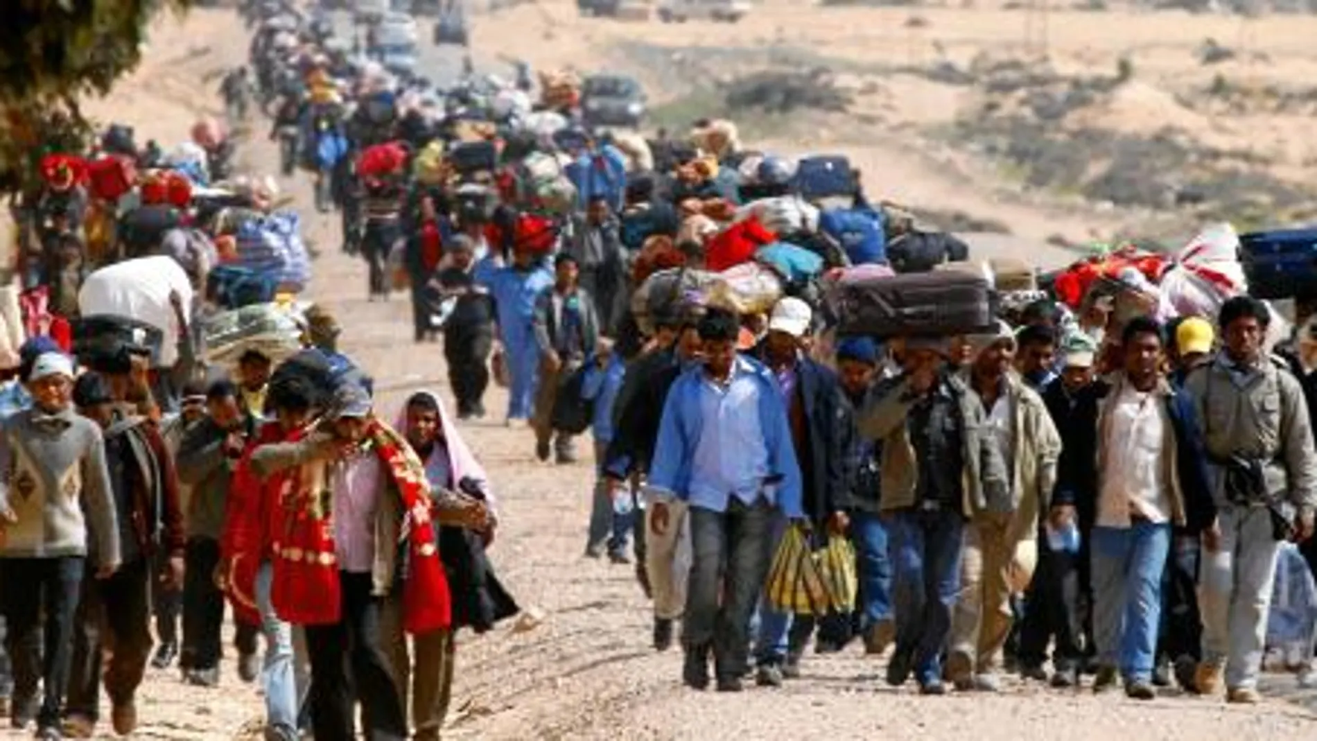 Miles de trabajadores bengalíes caminan, con sus pertenencias, hasta la frontera de Túnez huyendo de los combates en Libia