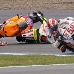 El piloto italiano de Ducati Valentino Rossi y el australiano de Honda Casey Stoner sufren una caida en su lucha por alcanzar la posición del italiano de Honda Marco Simoncelli