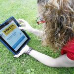 Una joven observa atentamente en el ipad la futura página web