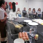 Una cocinera imparte un taller de cocina para varias personas celiacas