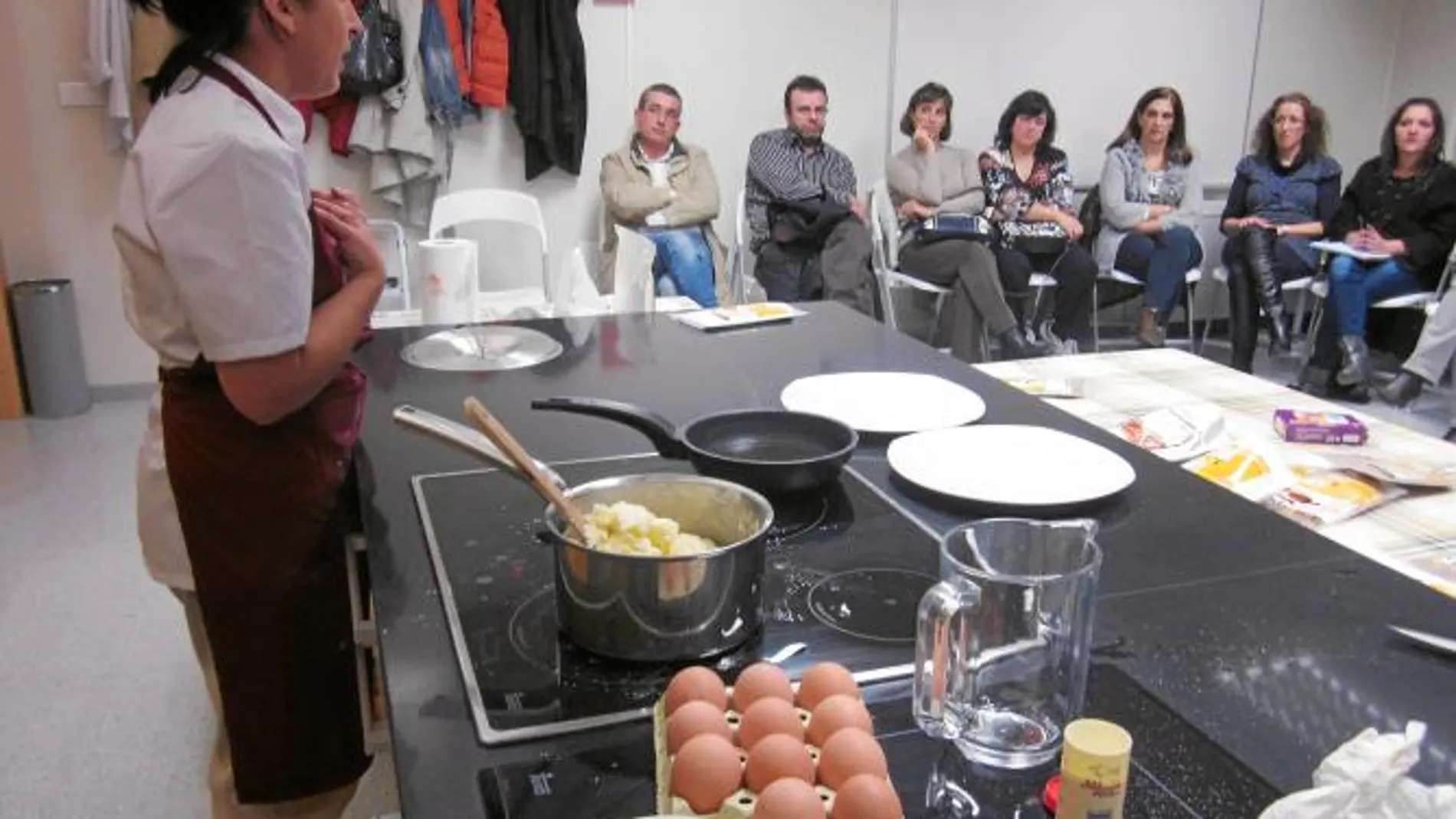 Una cocinera imparte un taller de cocina para varias personas celiacas