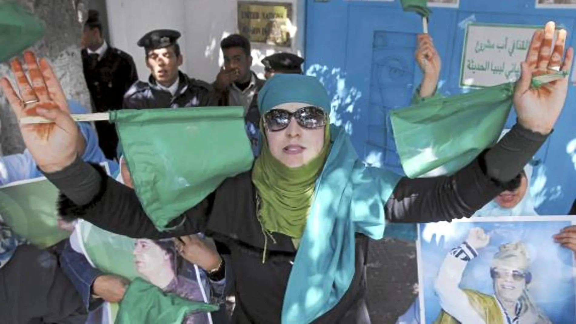 Una simpatizante de Gadafi porta dos banderas verdes, símbolo del régimen, ayer en Trípoli