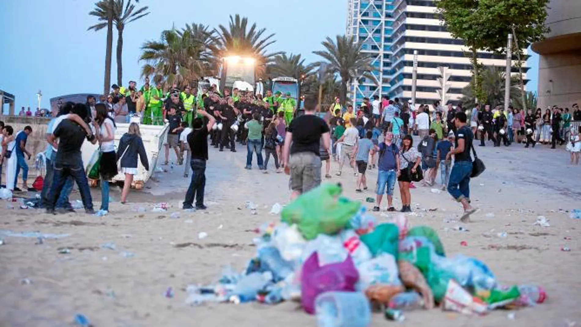 La Guardia Urbana desalojando ayer a las 6.00 horas una playa de Barcelona para que entraran los servicios de limpieza