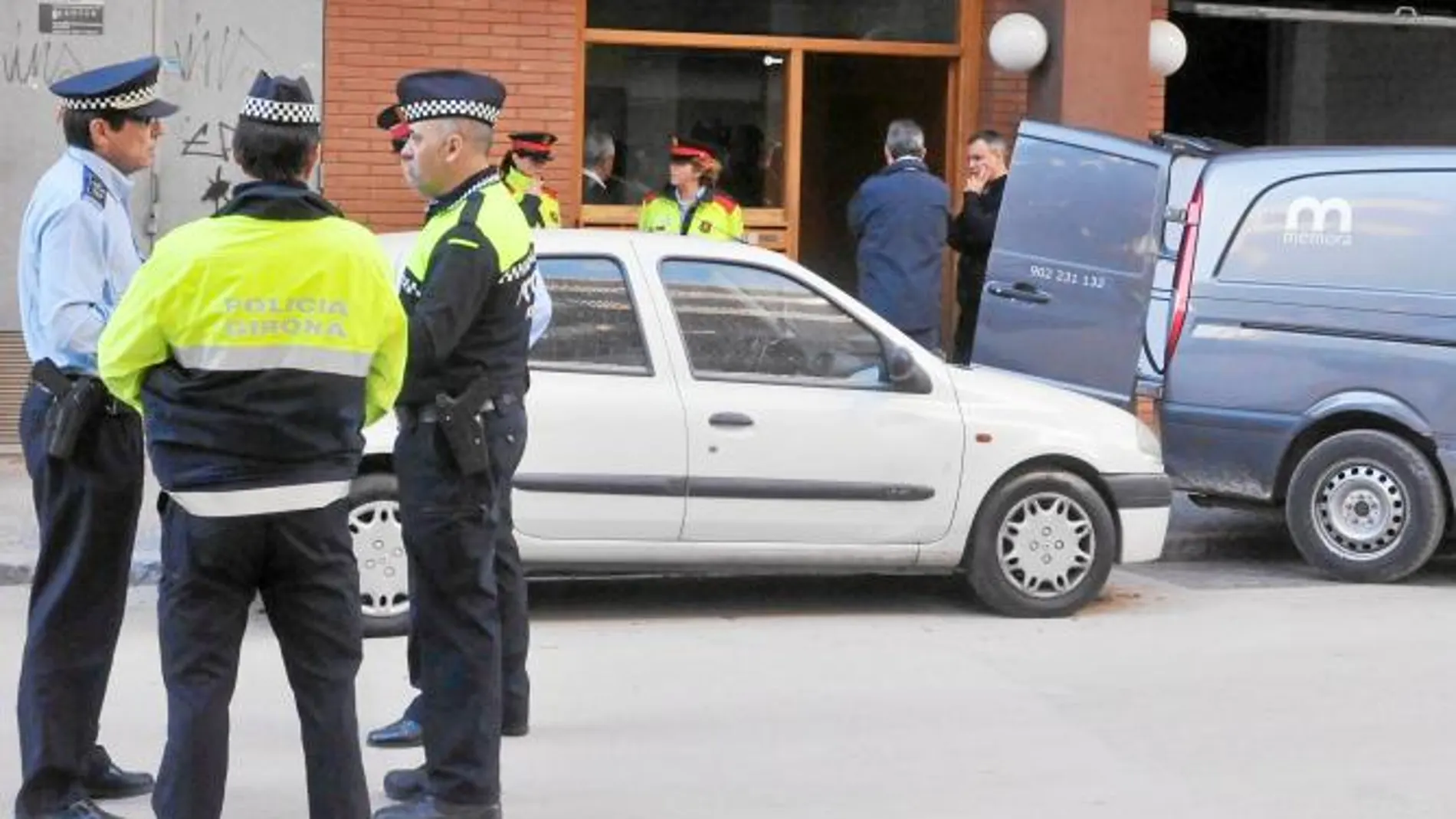 Los servicios funerarios esperan la salida del cadáver ante el portal