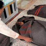 Un manifestante cubre la cara de un miliciano muerto, ayer, en Saná