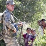 Un soldado turco junto a varios niños sirios que esperan la autorización para entrar en Turquía