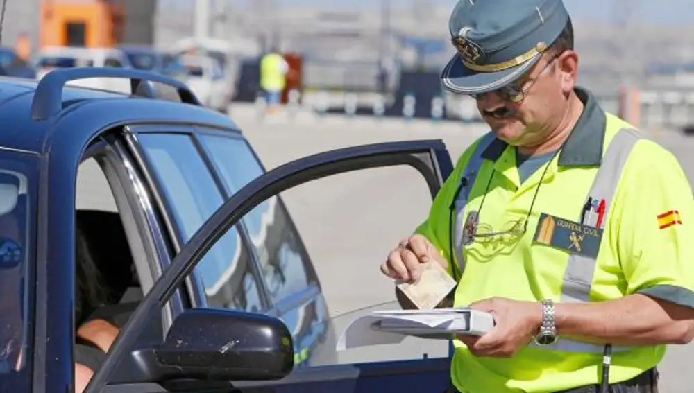 Un agente cobra una multa en una reciente campaña de control de velocidad de la Guardia Civil