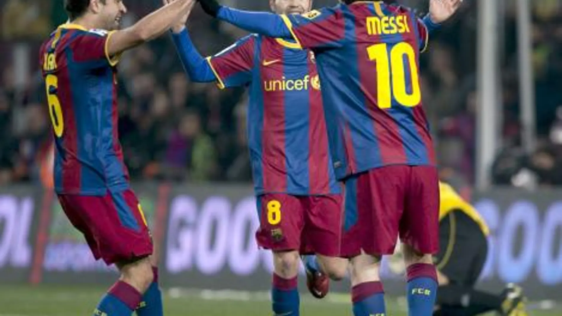 los centrocampistas del FC Barcelona Xabi (i) e Iniesta (c) felicitan al argentino Leo Messi celebra tras marcar el tercer gol ante el Almería,