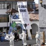 En la imagen, los encapuchados entran en la plaza del pueblo navarro con carteles en favor de los presos etarras.