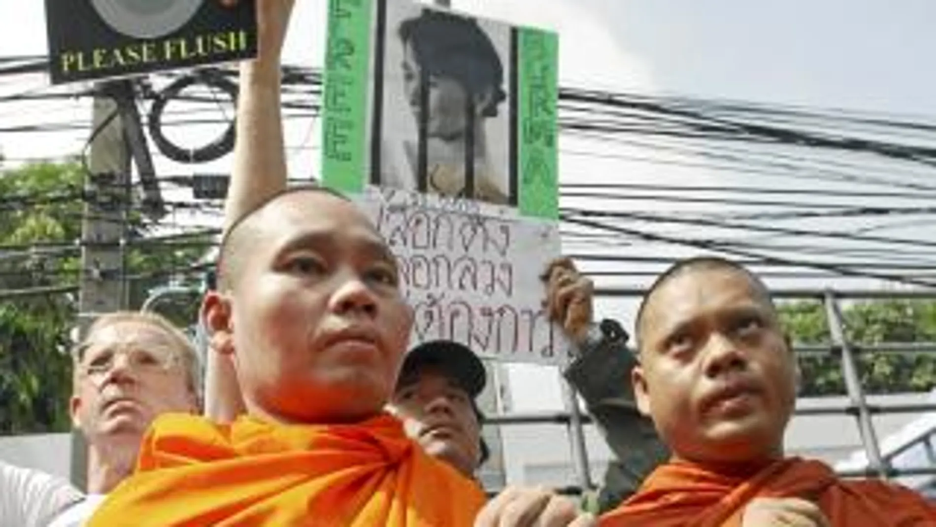 Dos monjes birmanos sujetan una pancarta con la cara de la opositora Aung San Suu Kyi, premio Nobel de la Paz y en arresto domiciliario