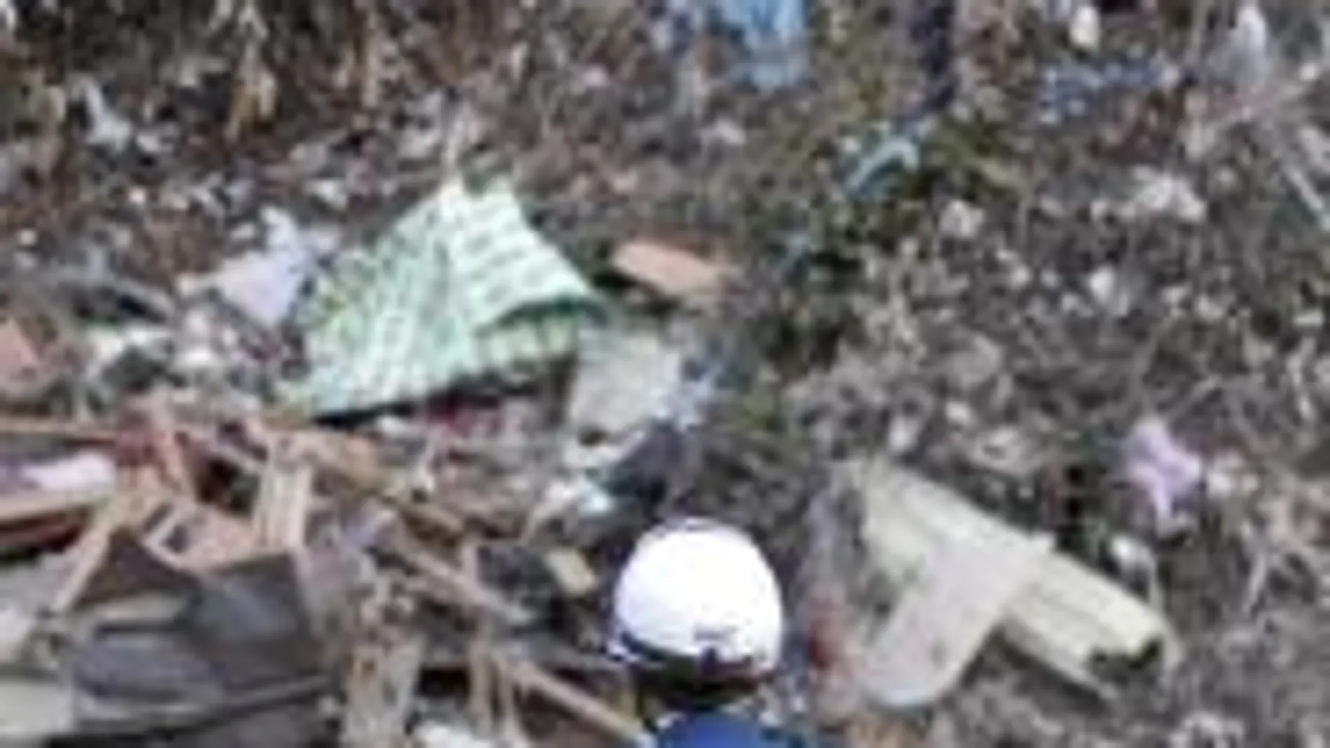 Un bombero contempla los restos de una casa destruida por el tsunami en la ciudad de Minamisanriku