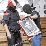 Dos agentes de la Ertzaintza retiran varios carteles y fotos de presos de ETA de la comparsa bilbaína «Kaskagorri» en agosto de 2009