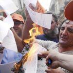 Funcionarios civiles quemaron ayer notas de pago de un impuesto en protesta por el plan de austeridad del Gobierno