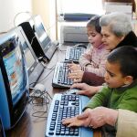 Unas vecinas de Villaharta (Córdoba), con sus nietos, aprenden a utilizar el ordenador gracias a un proyecto de la diputación de Córdoba