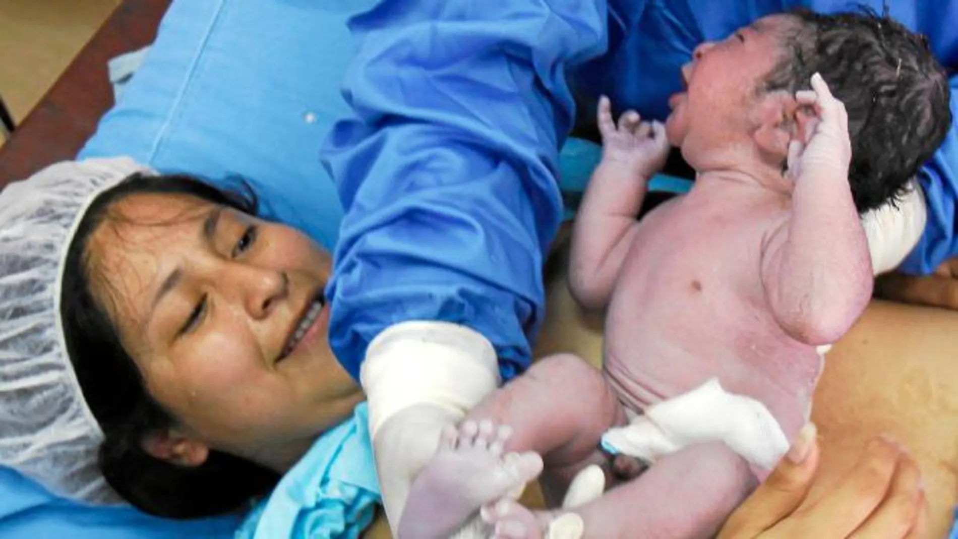 En la imagen, una mujer da a luz a su bebé