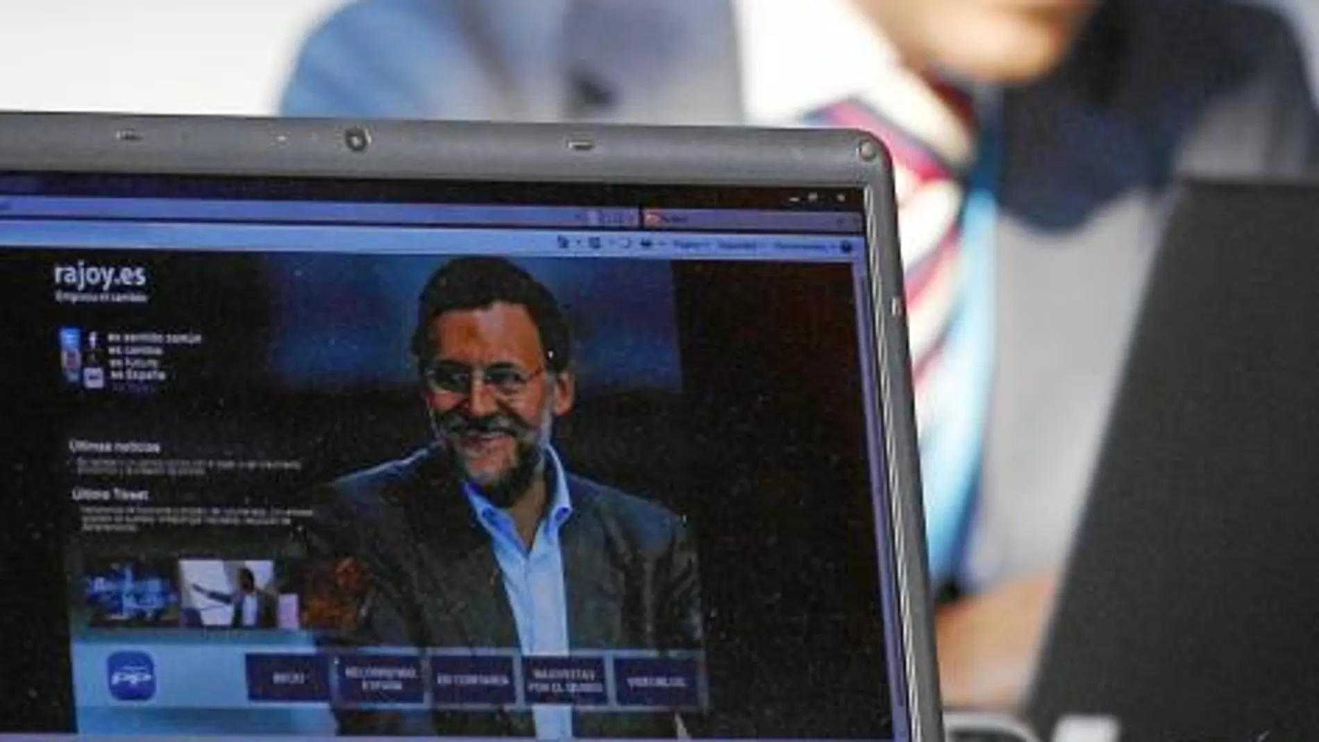 Un asistente a la convención visualiza la web de Rajoy