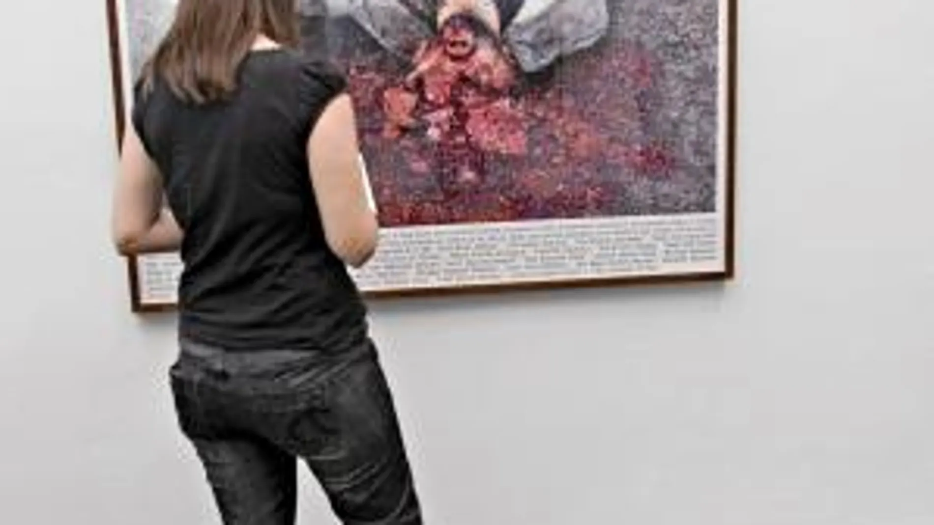 Una visitante observa el Googlegrama de Joan Fontcuberta en el que muestra una víctima de Irak