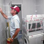 Un obrero pasa la llana por una cocina, durante las obras de rehabilitación de una vivienda