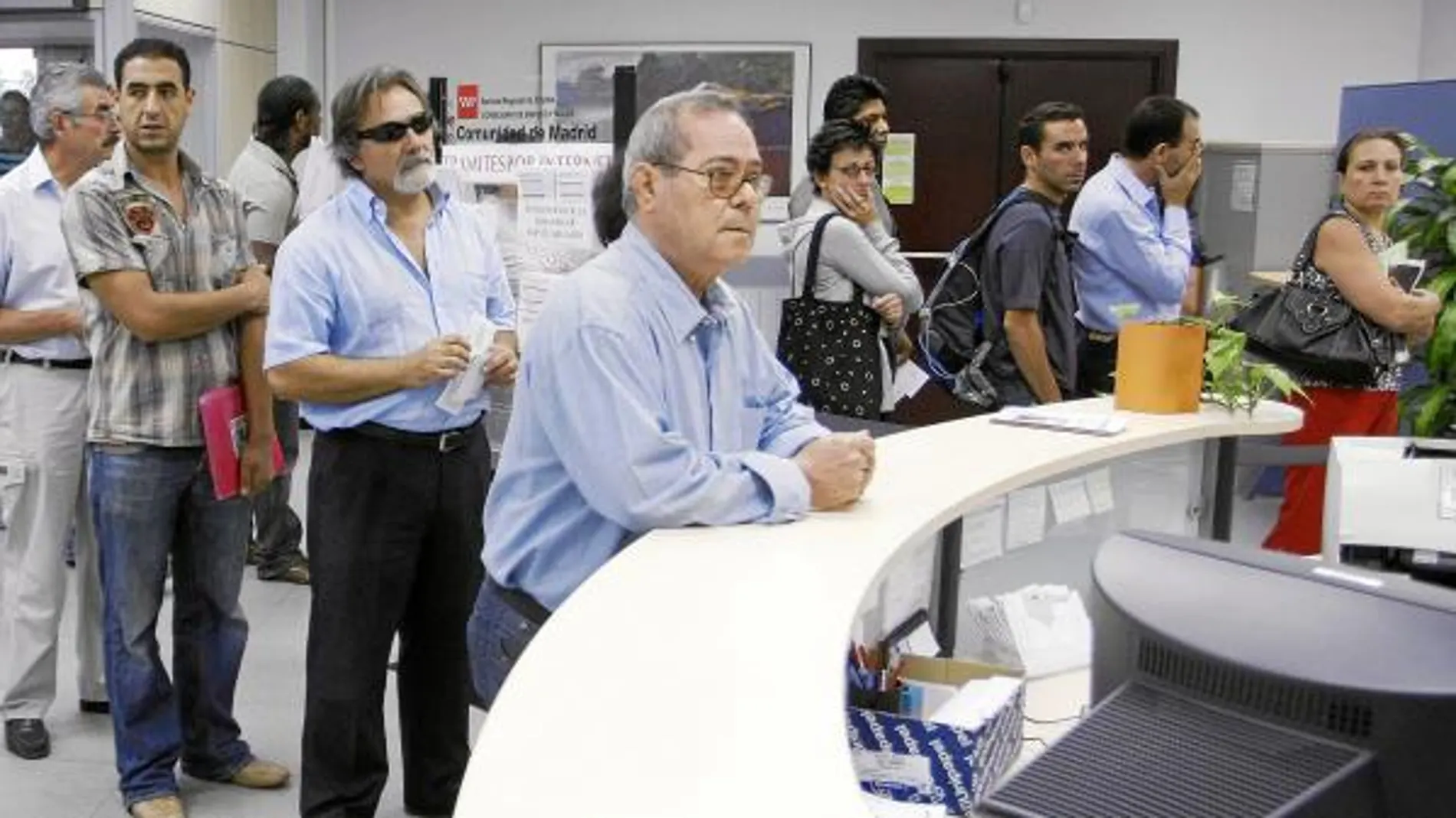 Un grupo de parados de larga duración en las colas de una oficina de empleo