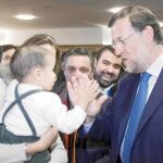 Mariano Rajoy hace carantoñas a un bebé en la clausura de la Intermunicipal que el PP ha celebrado en Zaragoza