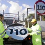 Dos operarios se disponen a colocar el adhesivo con la limitación a 110 por hora en las cercanías de Tordesillas