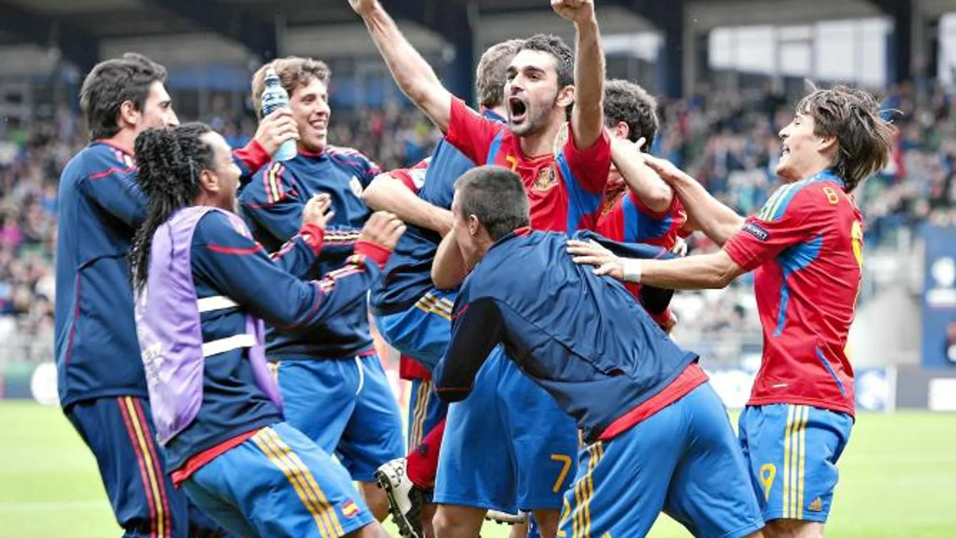 Los suplentes de España saltan al césped para felicitar a Adrián por el tanto del empate ante Bielorrusia