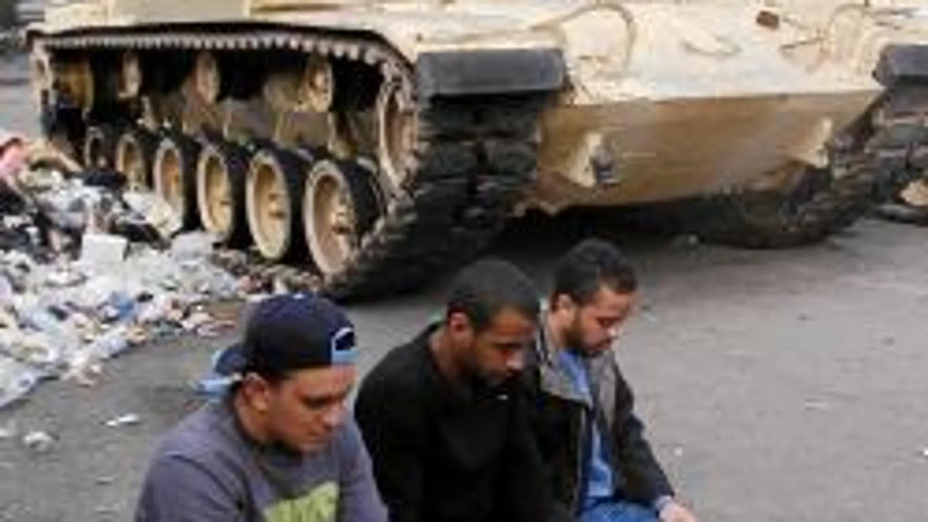 Varios jóvenes interrumpen sus protestas para orar en la plaza cairota de Tahrir, epicentro de la revuelta contra el régimen de Mubarak