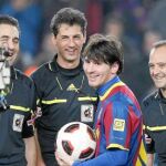 Messi, junto al trío arbitral, después de que le entregaran el balón del partido por marcar tres goles