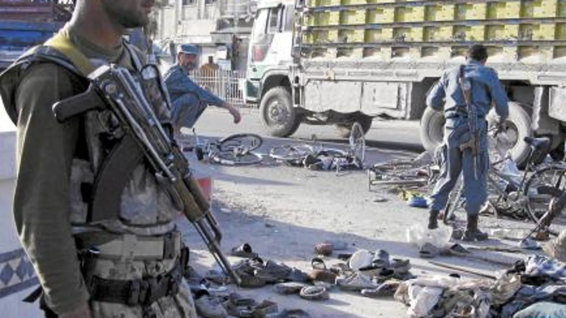 Un policía afgano vigila, ayer, una calle de Kandahar tras una explosión