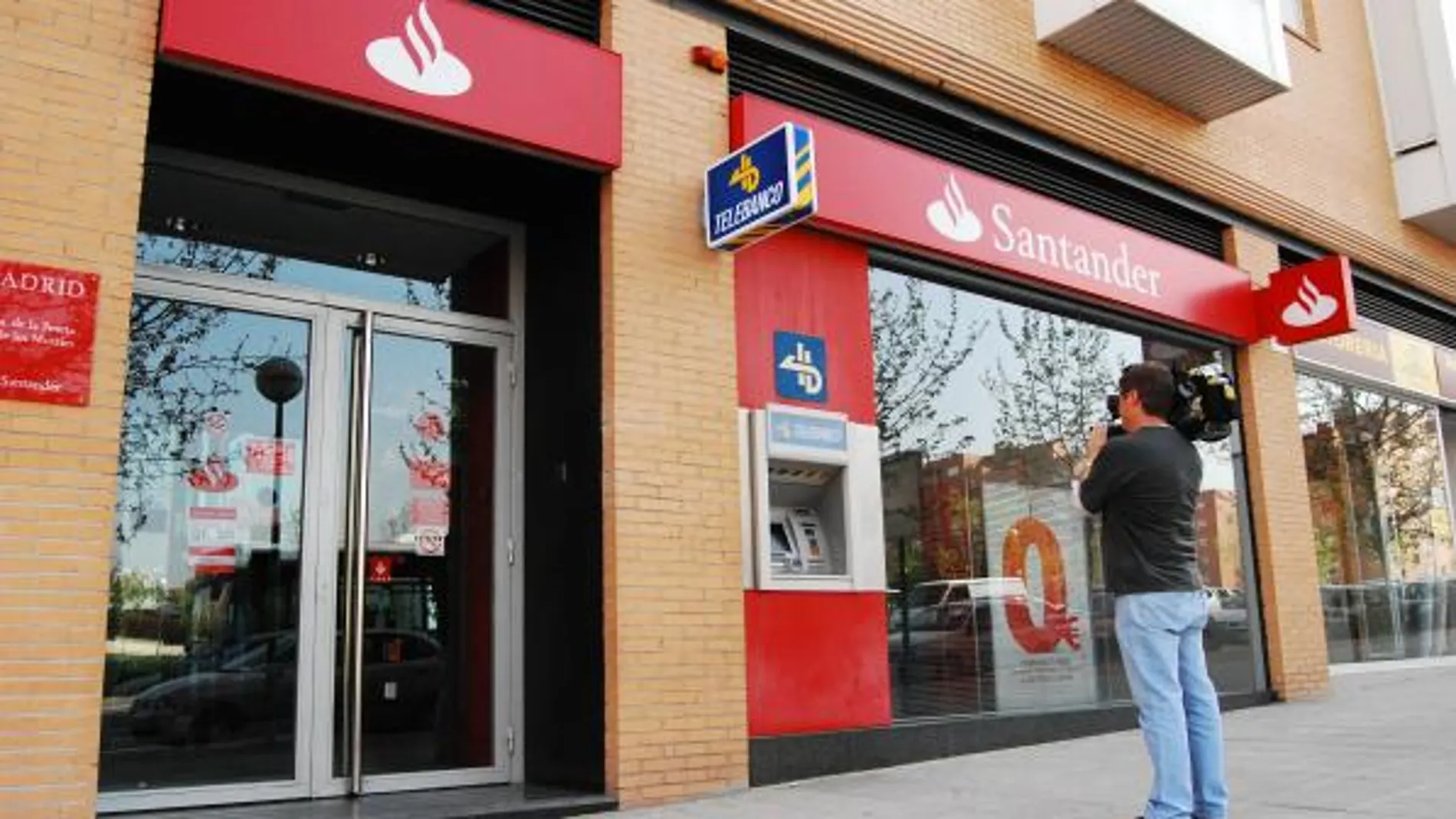 Un cámara toma imágenes de la sucursal atracada, en la avenida de la Peseta