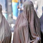 Tres mujeres ataviadas con burkas en una calle de Peshawar, al noroeste de Pakistán