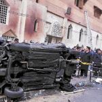 Policías egipcios montan un cordón de seguridad en torno a un coche destrozado en el atentado perpetrado en Alejandría el 31 de diciembre