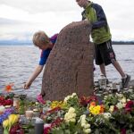 Jóvenes noruegos colocan flores en la isla de Utoeya en homenaje a las víctimas del tiroteo