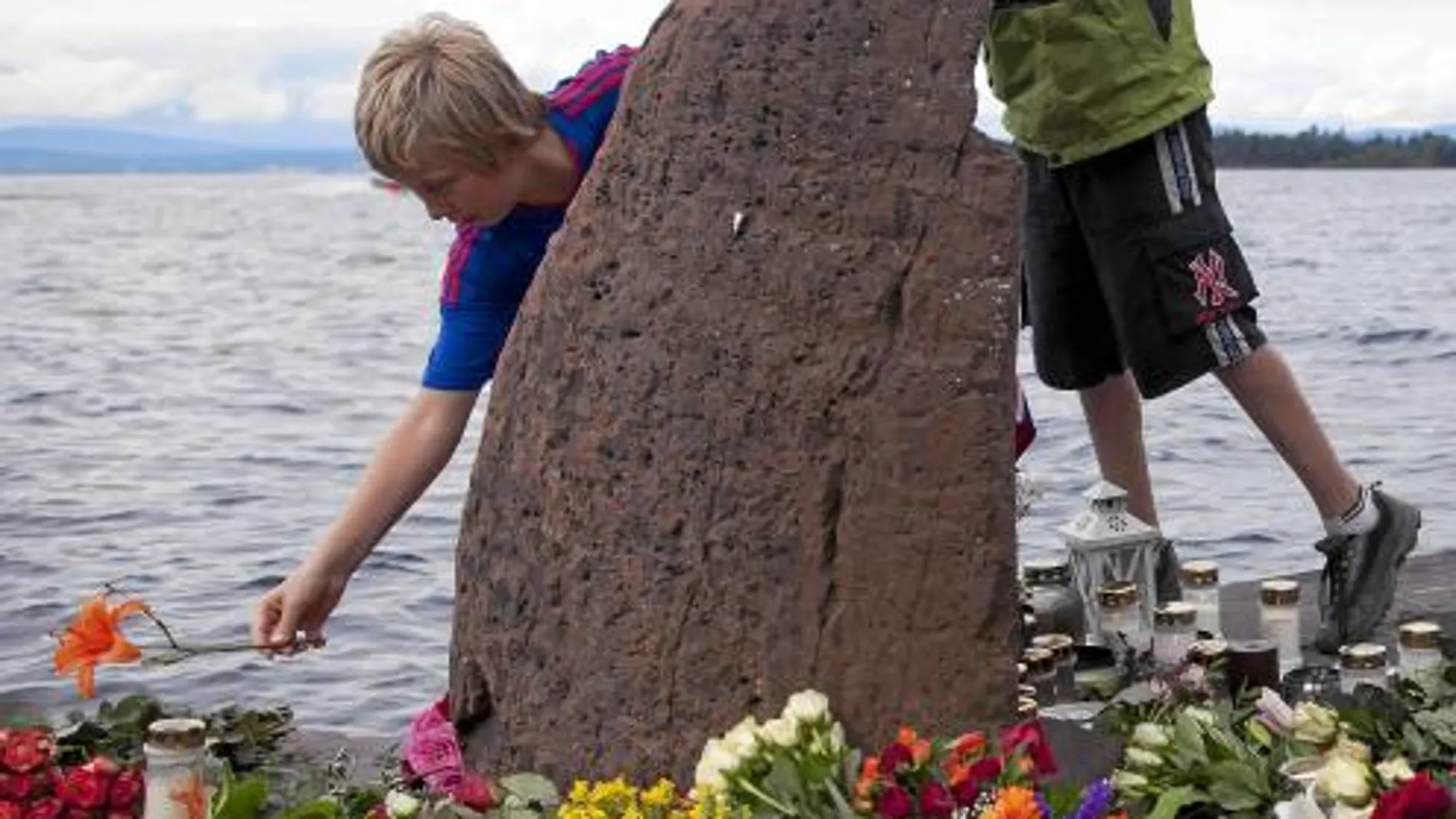 Jóvenes noruegos colocan flores en la isla de Utoeya en homenaje a las víctimas del tiroteo