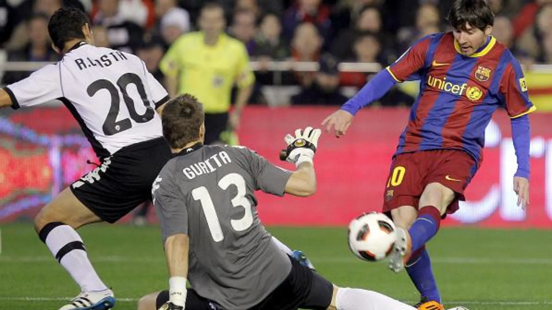 El delantero argentino del F. C. Barcelona, Leo Messi (d), intenta batir al guardameta del Valencia, Vicente Guaita (c)