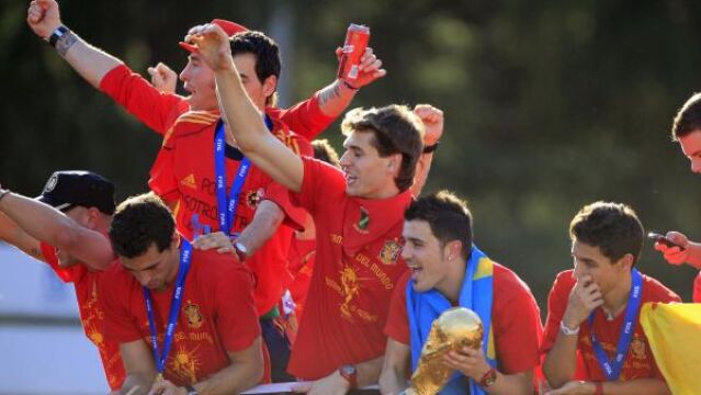 El delantero de la selección española de fútbol, David Villa, sostiene la Copa del Mundo junto a sus compañeros, en el autobús descapotable que les pasea por las calles de Madrid