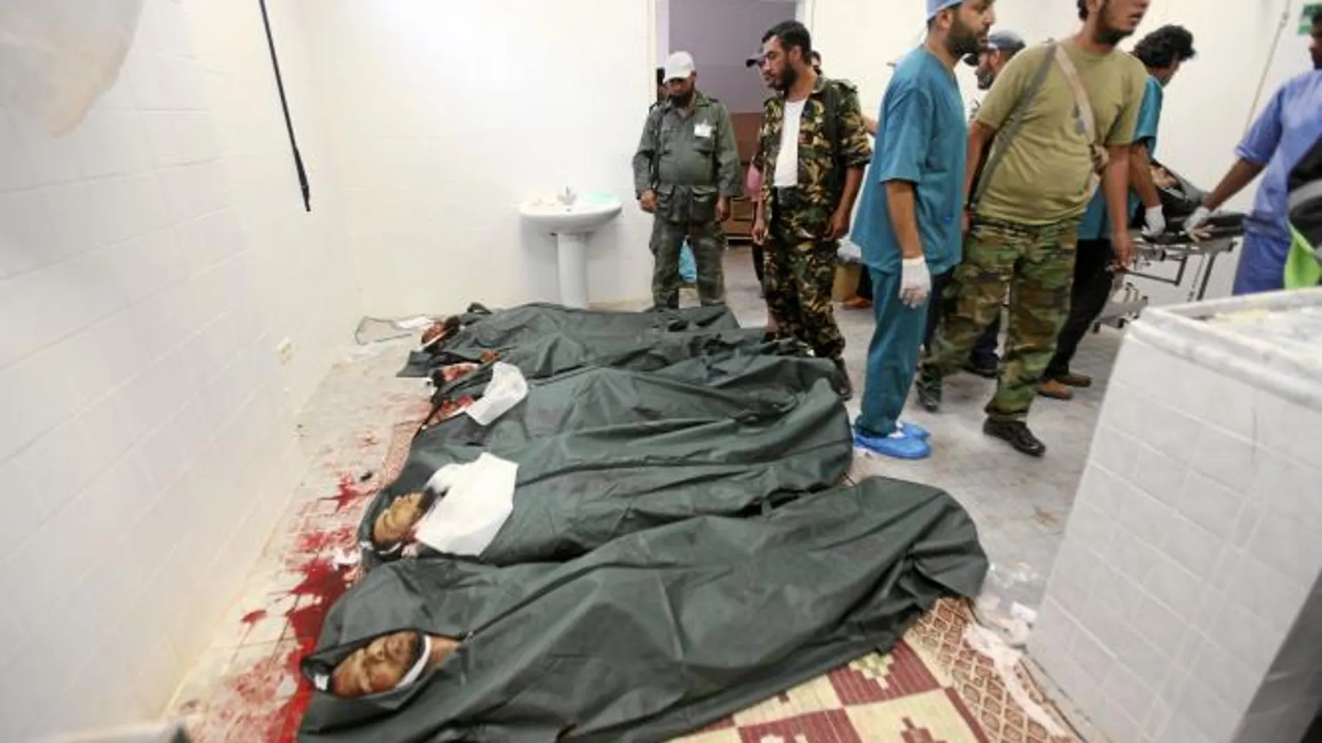 Cadáveres de rebeldes tras el ataque de los gadafistas en la refinería de Ras Lanuf, ayer