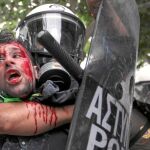 Un policía reduce a un manifestante durante los disturbios en Atenas con ataques a ministerios y diputados