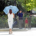 Una mujer se protege del sol con un paragüas en la ciudad de Murcia