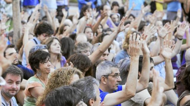 Arriba, los «indignados» en la asamblea celebrada ayer en la plaza del Carmen de Madrid, en la que debatieron sobre la reforma constitucional